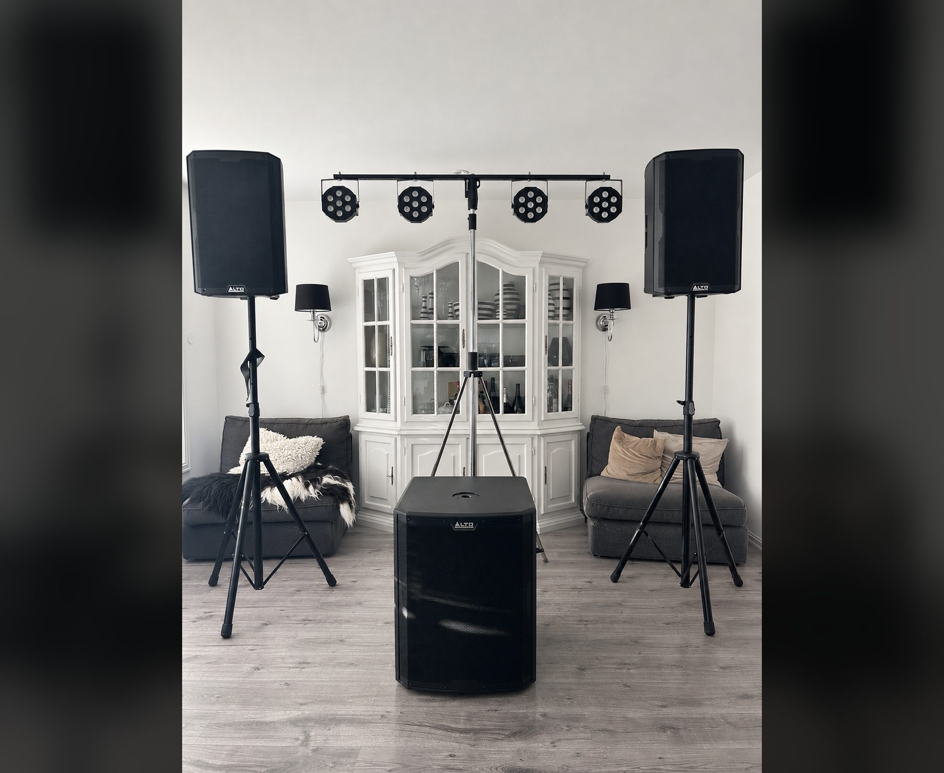 FestRiggen rigget opp i en stue: to høyttalere på stativ, 18 tommers subwoofer og lysbom